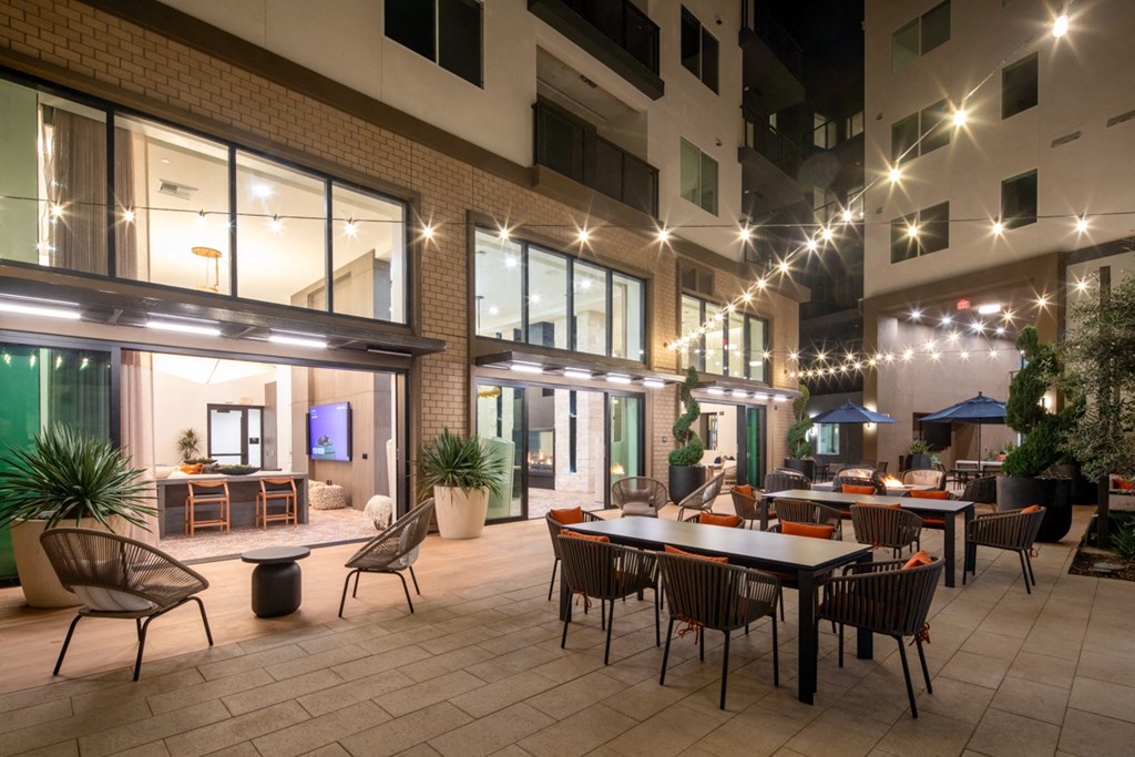 a rendering of a patio with tables and chairs at night