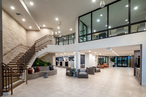 a large living room with a staircase and a lobby with furniture