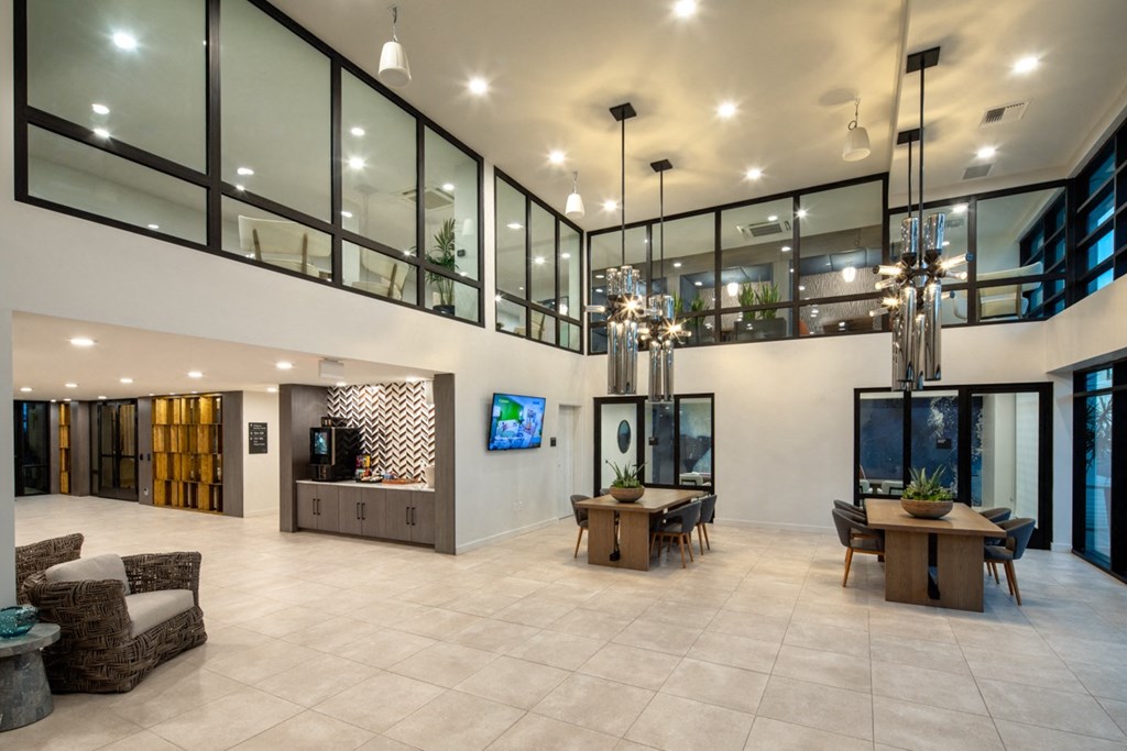 the lobby of a building with large glass windows and a large lobby area with furniture