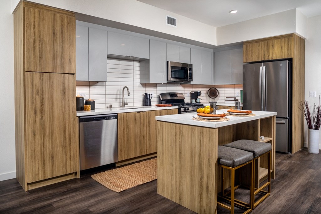 a kitchen with stainless steel appliances and a large island with a breakfast bar