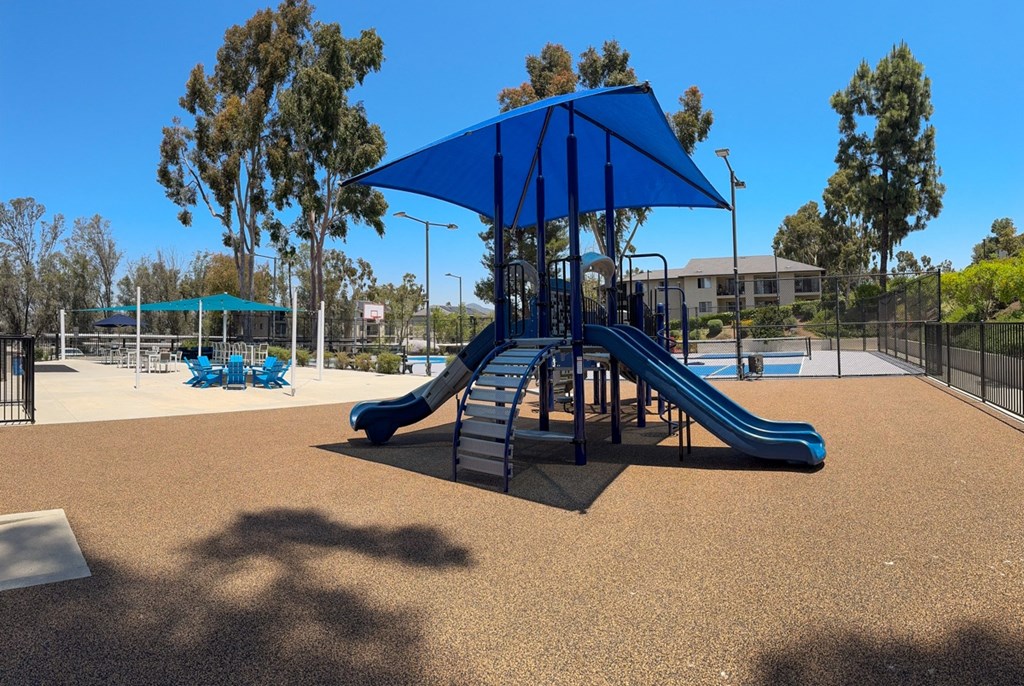a playground with a swing set and a blue pavilion