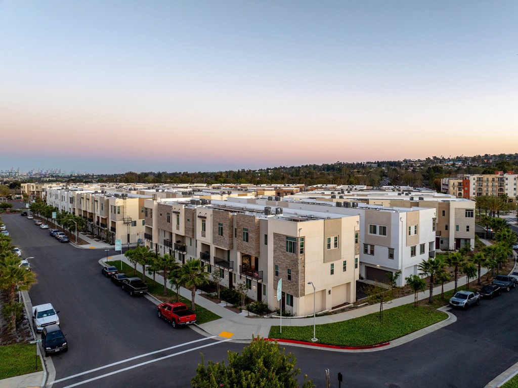 A street view of a residential area with cars parked on the side of the road.