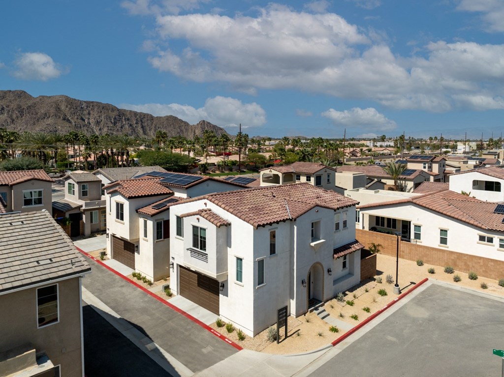 an aerial view of a neighborhood of houses with mountains in the background