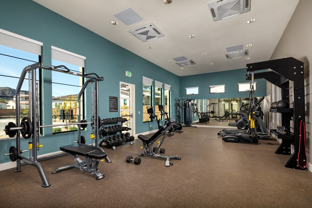 a gym with weights and other exercise equipment on the floor and windows
