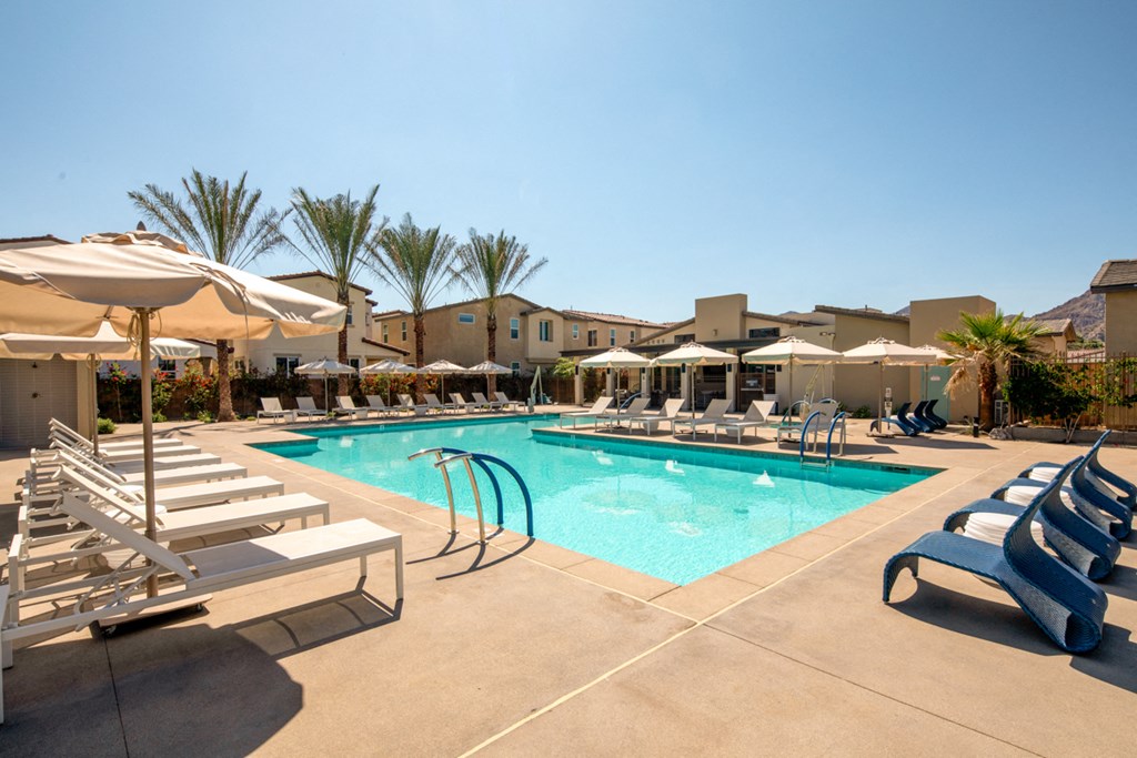 a swimming pool with lounge chairs and umbrellas at the resort