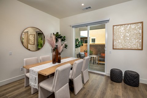 a dining room with a table and chairs and a mirror on the wall