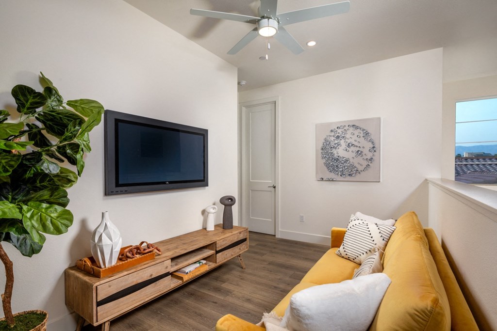 a living room with a yellow couch and a tv