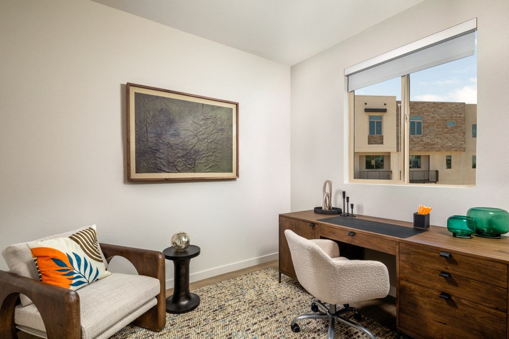 a home office with a desk and chair and a window