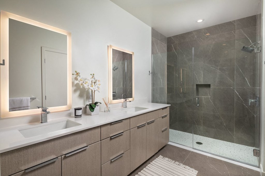 a bathroom with two sinks and a walk in shower