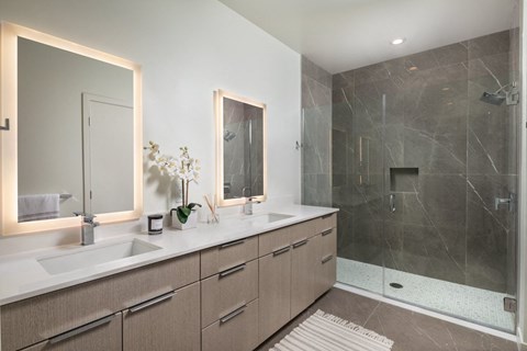 a bathroom with two sinks and a walk in shower