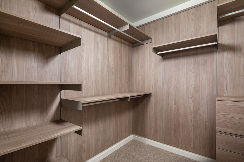 a walk in closet with wooden walls and shelves