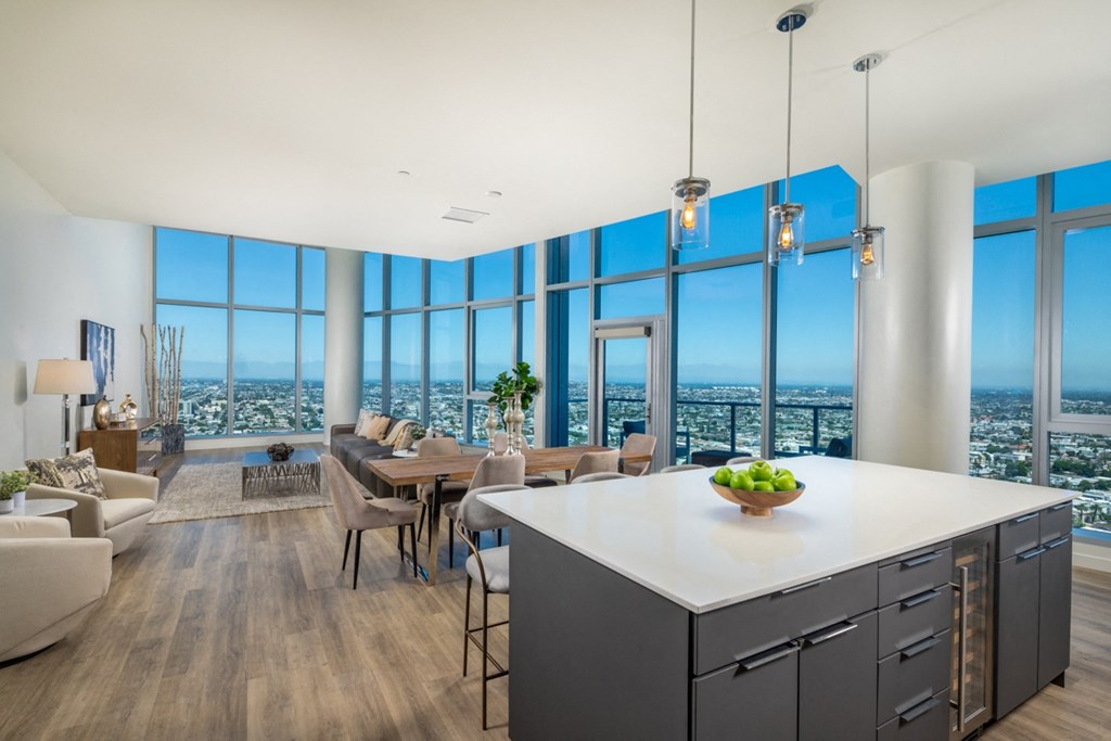 an open concept living room and dining room with a large window and a view of the city