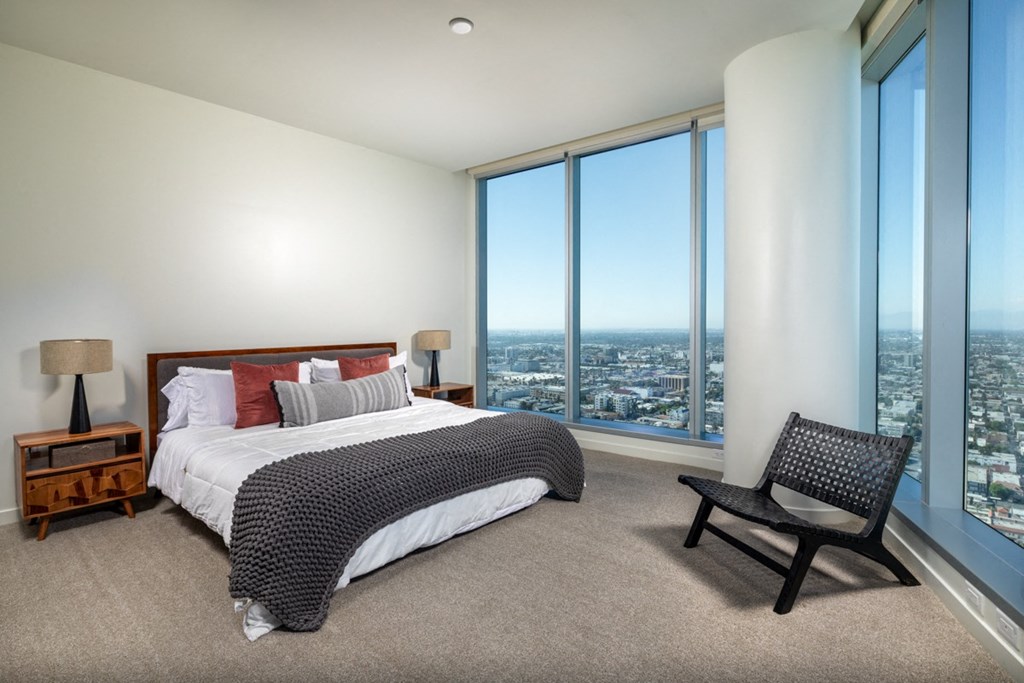 a bedroom with a bed and a chair in front of a window