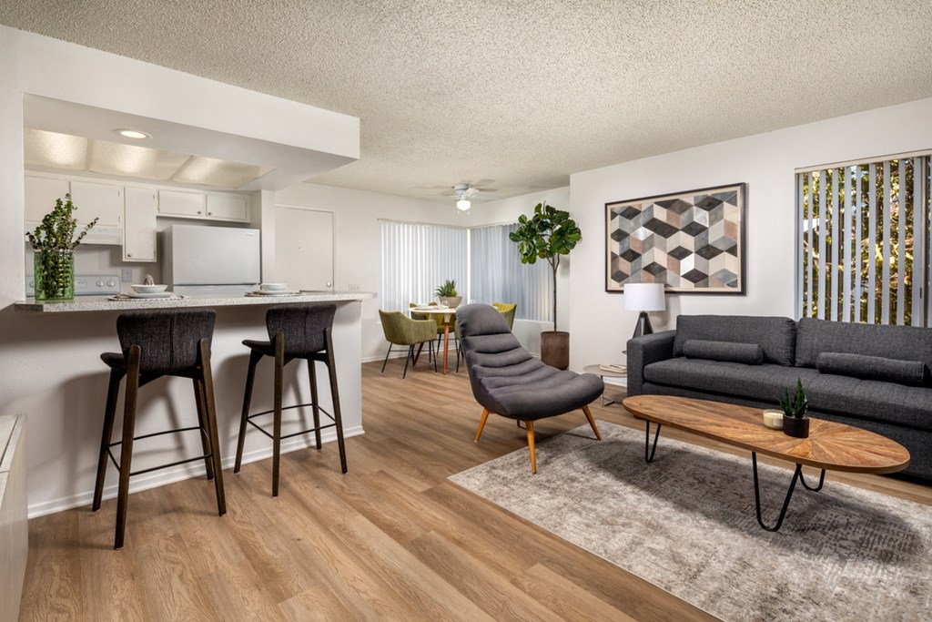 A modern living room with a grey sofa and wooden floors.
