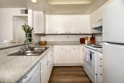 A kitchen with white cabinets and appliances.