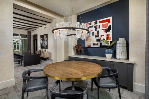 a dining room with a round table and a chandelier