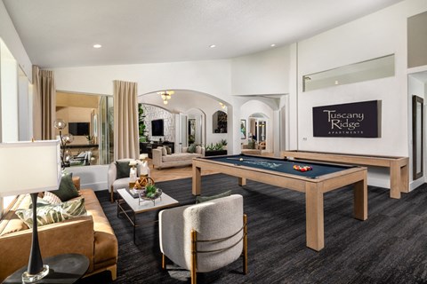 A living room with a pool table and a sign that says Tuscany Ridge.