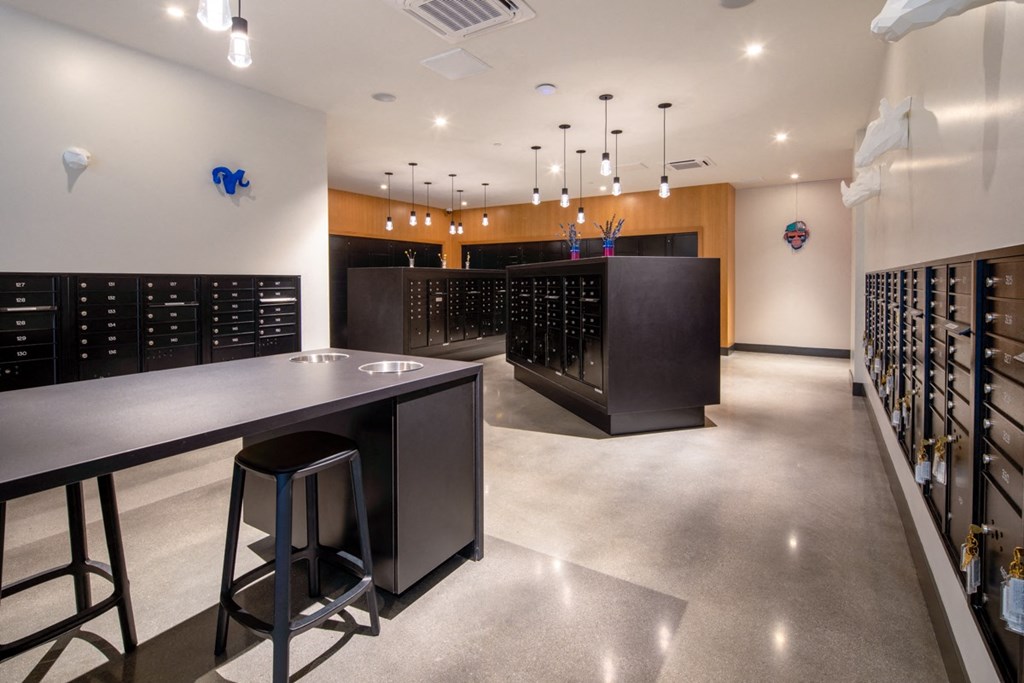 a tasting room with rows of wine racks and a counter with two stools