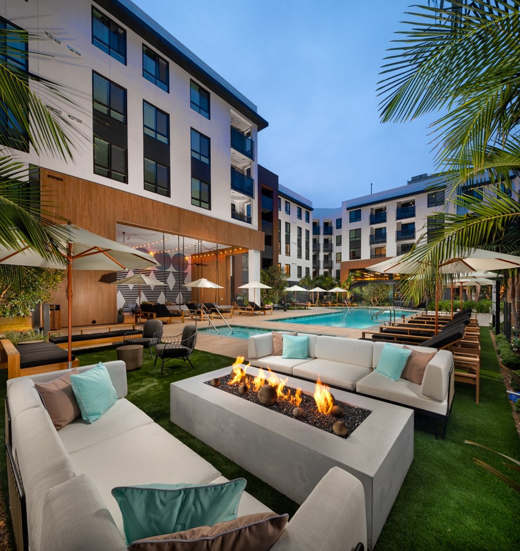 an outdoor patio with couches and a fire pit