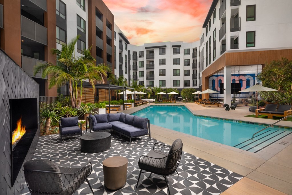 a swimming pool at a hotel with chairs and a fireplace