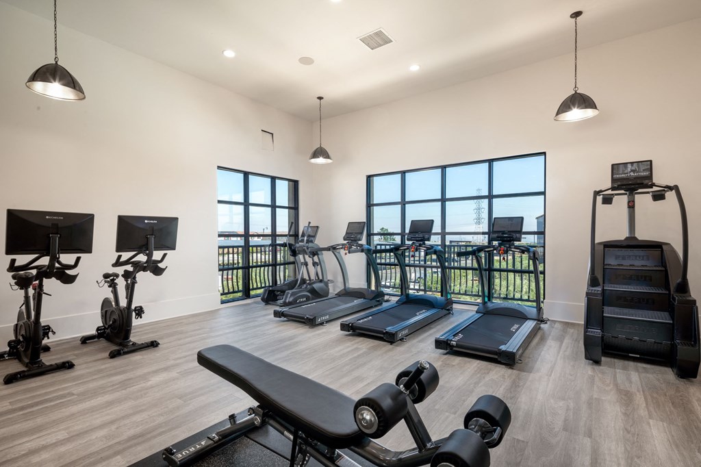 a gym with cardio equipment and exercise machines at the bradley braddock road station apartments