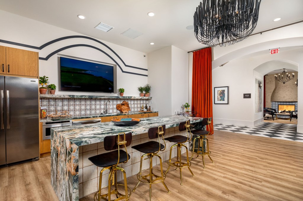 a kitchen with a long counter and a tv on the wall