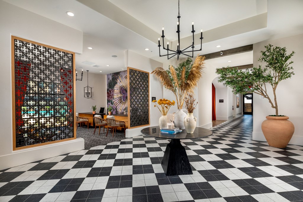 a lobby with a black and white checkered floor and a large painting on the wall