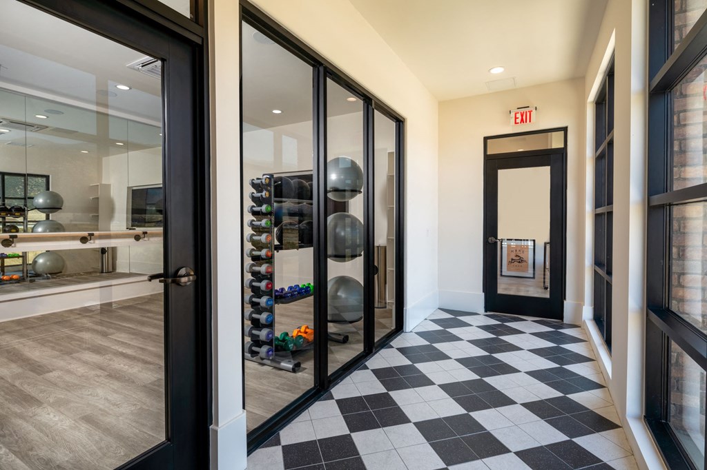 a hallway with black doors and a black and white checkered floor