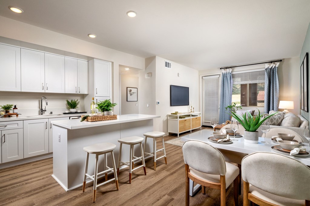 a kitchen and dining area with white cabinets and a table and chairs