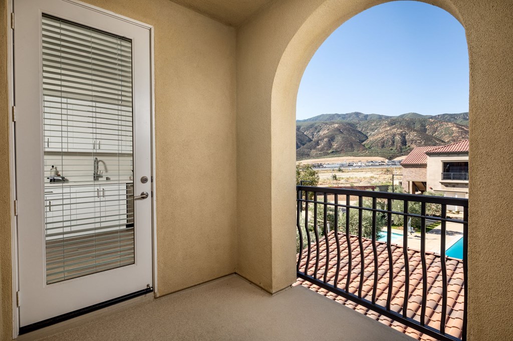 a balcony with a door and a view of the mountains