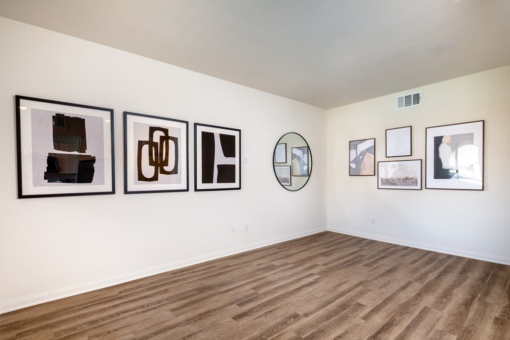 a room with pictures on the wall and wooden floors