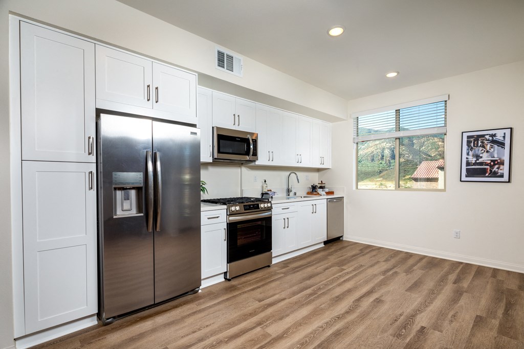 a kitchen with stainless steel appliances and white cabinets