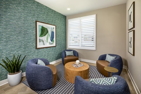 A living room with a green wall and a painting on it.