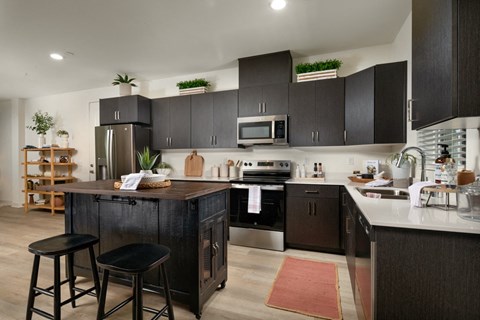 view of a kitchen with a large island and black cabinets