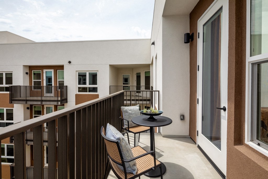 a balcony with two chairs and a table at VORA LUX, San Diego California