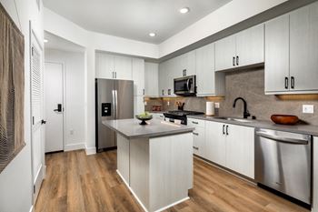 Kitchen with white cabinets and stainless steel appliances at VORA LUX, Mission Valley, California, 92120
