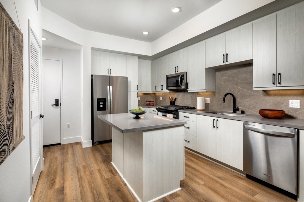 a kitchen with white cabinets and stainless steel appliances at VORA LUX, San Diego California