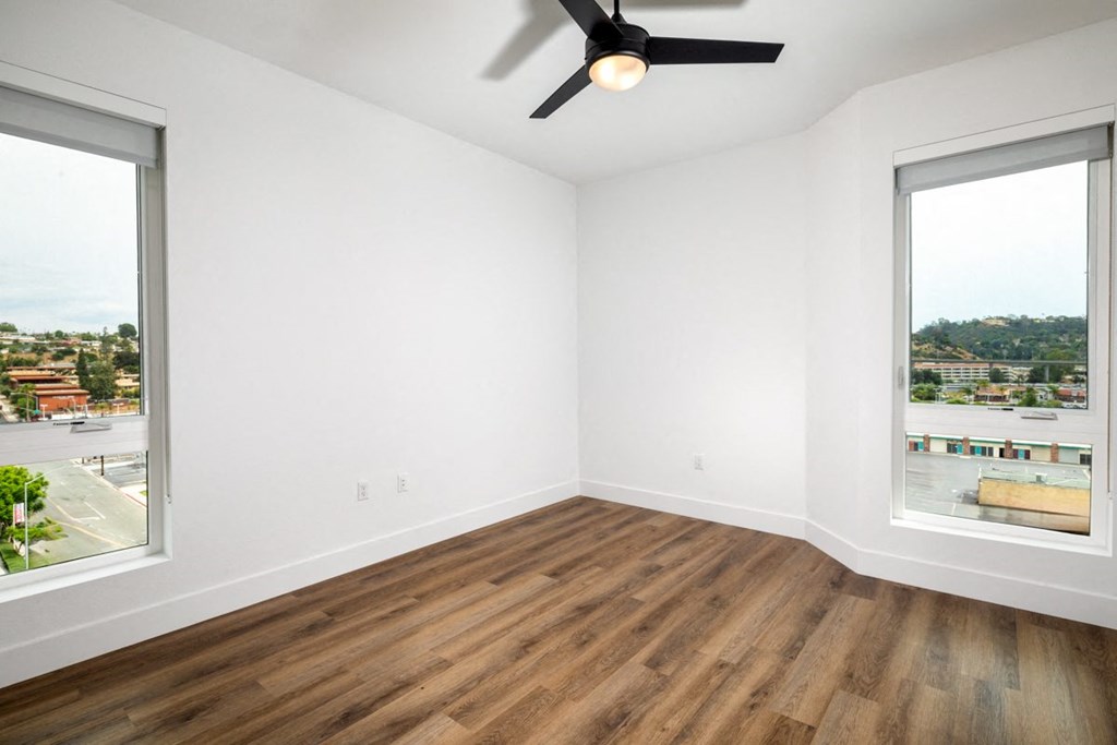 an empty room with two windows and a ceiling fan at VORA LUX, San Diego