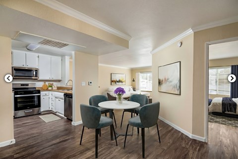 A kitchen with a dining table and chairs.