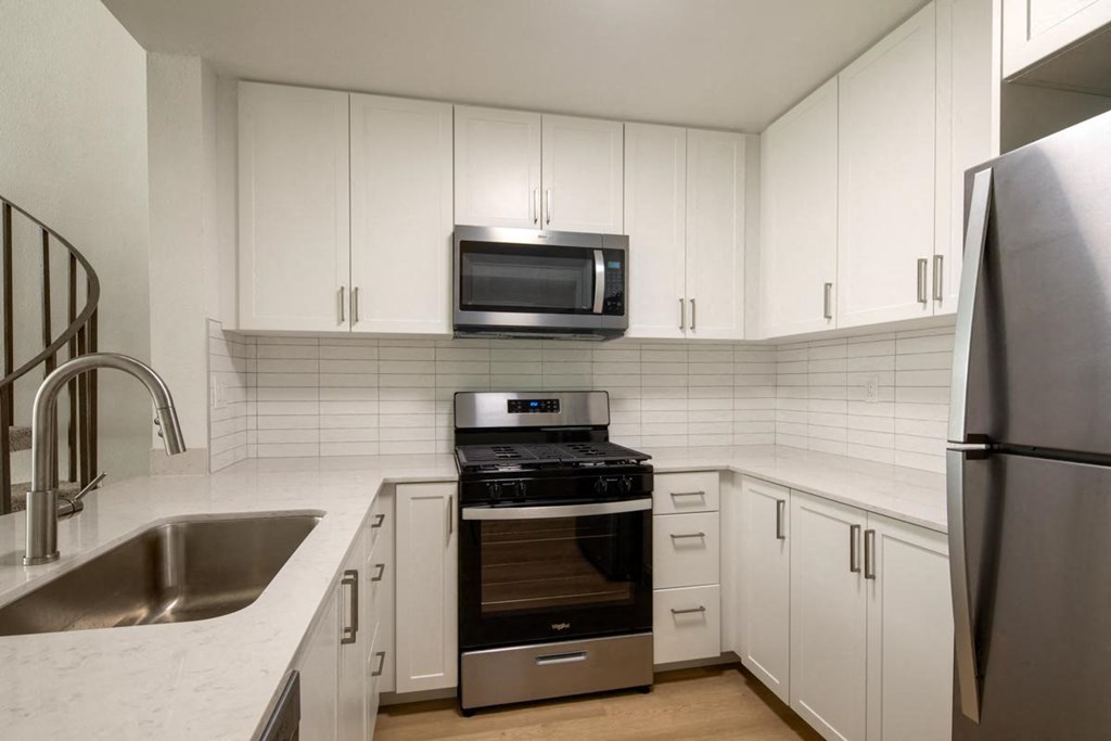 A kitchen with white cabinets and stainless steel appliances.