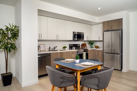 A modern kitchen with a dining table set for two.