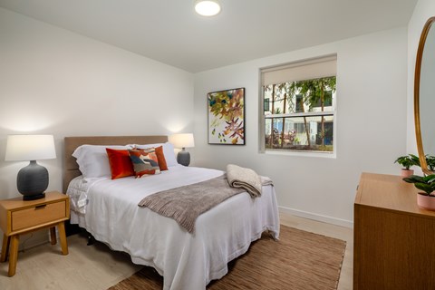 A bedroom with a large bed and a mirror on the wall.