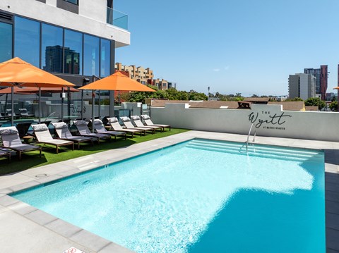 a pool on the rooftop of a building with umbrellas