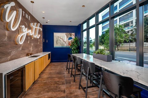 A restaurant with a counter and chairs with a sign that says The Wytt.