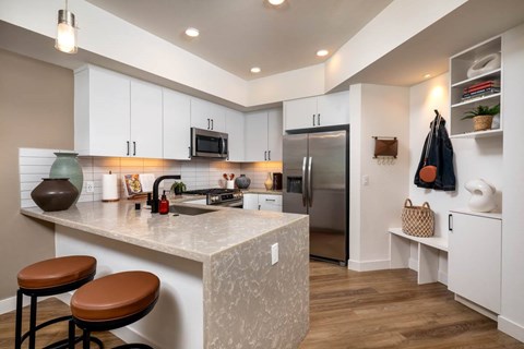 A kitchen with a marble countertop and a refrigerator.