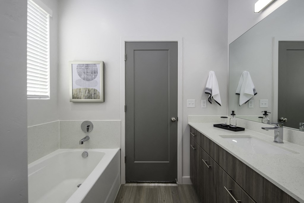 a bathroom with a tub and a sink and a door