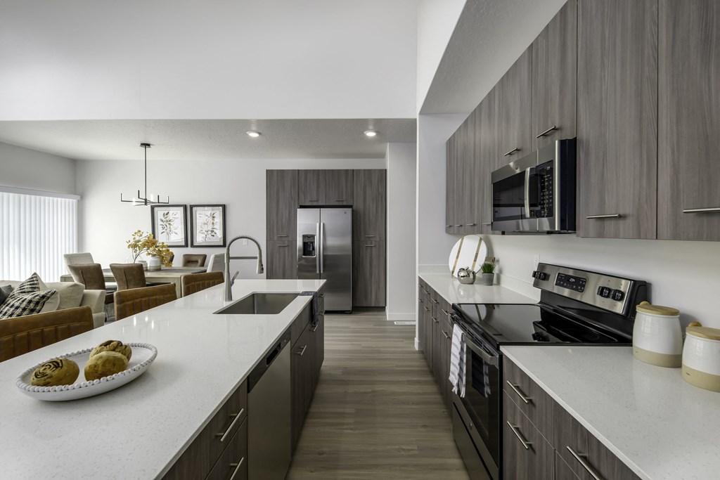 a kitchen and living room with a white counter top and