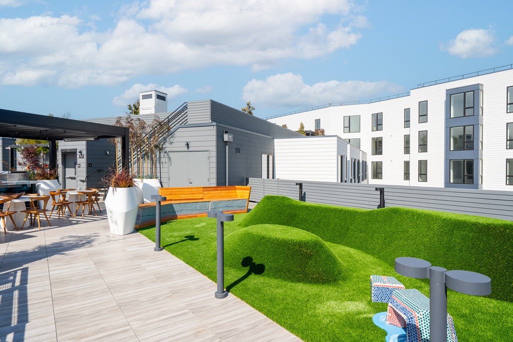 a terrace with a bench and tables on a sunny day