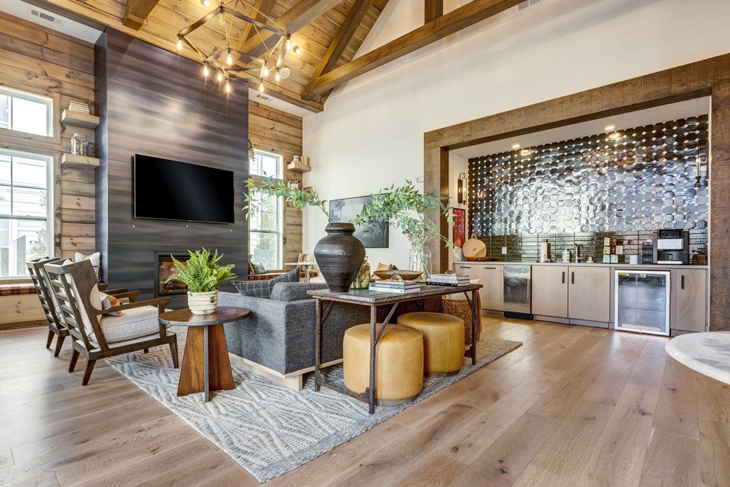 a living room with a gray couch and a table with stools