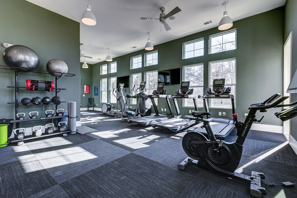 a gym with weights and cardio equipment at the belgard apartments